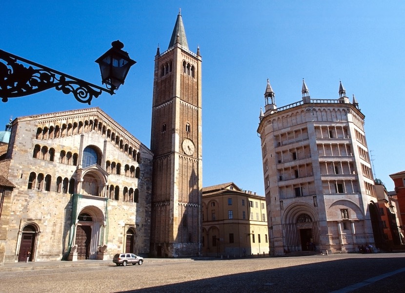 Ein Platz in Italien mit einer Kirche mit Kirchturm und anderen älteren Gebäuden.